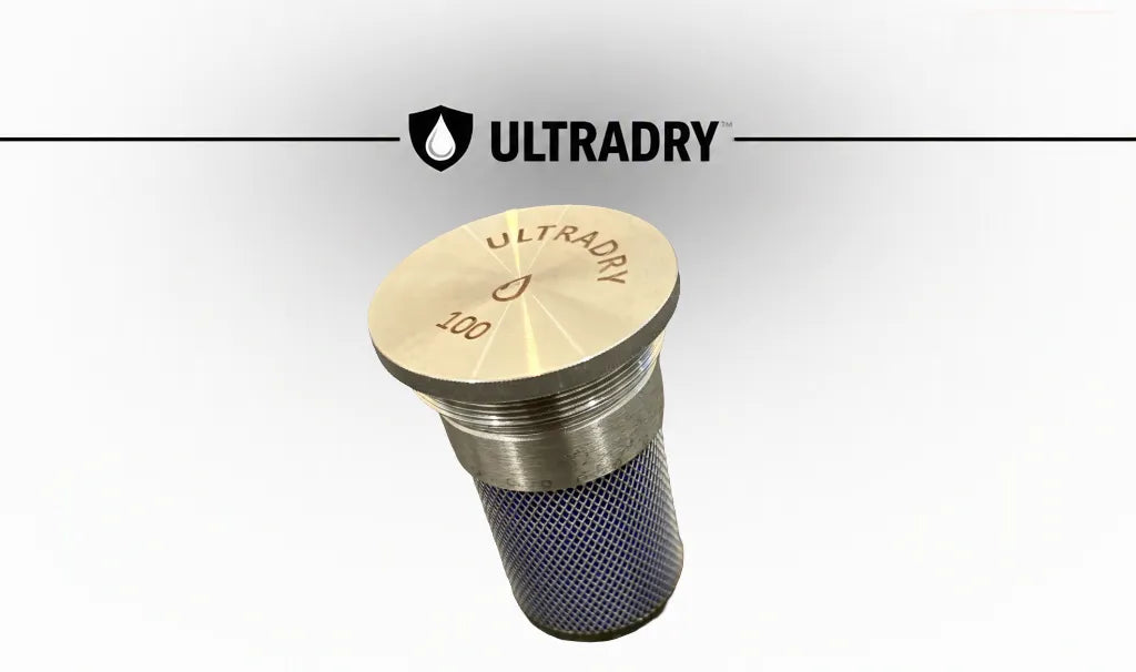 An ULTRADRY 100 gram moisture sieve cartridge with a stainless steel top cap, a stainless steel mesh body filled with blue silica desiccant, shown against a white background with the ULTRADRY brand logo at the top.